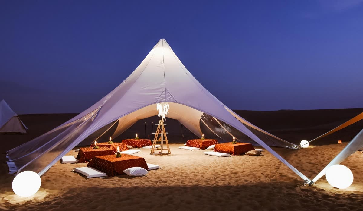 Lantern-lit dining tent in the desert at dusk
